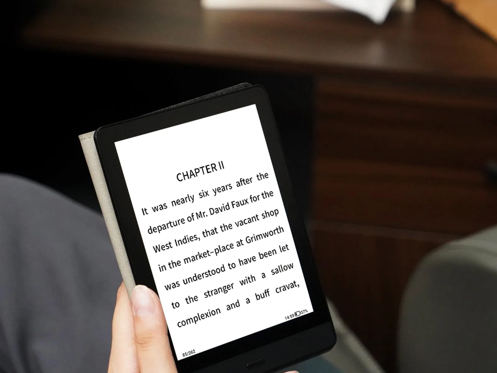 Bigme Read dipegang satu tangan, layar menampilkan halaman novel